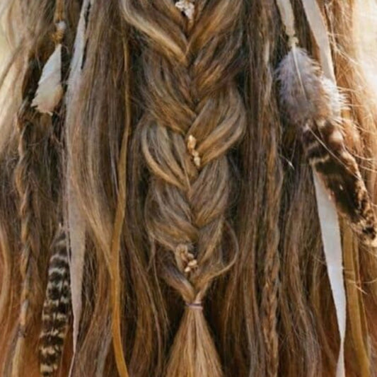 Woman with braided hair adorned with decorative elements in a natural setting